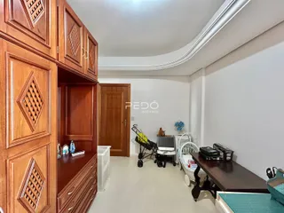 Interior de um cômodo com armários de madeira escura e porta de madeira.