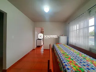 Este é um quarto com cama e janela com cortinas brancas.