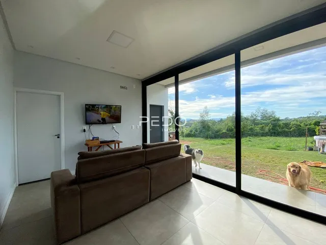 Sala de estar com grande janela de vidro voltada para o jardim.