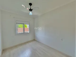 Esta é uma foto de uma sala de estar com piso de madeira clara e paredes brancas.