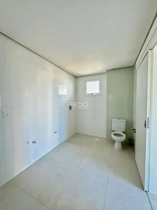 Banheiro com piso claro e paredes brancas.