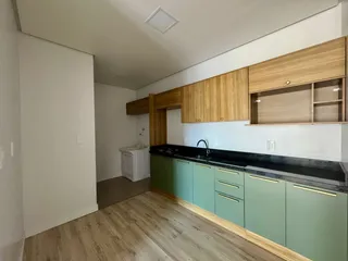 Uma cozinha com armários de madeira e bancada escura é visível na propriedade.