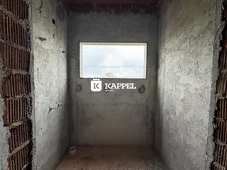 Foto de um cômodo com paredes de concreto aparente e uma janela.