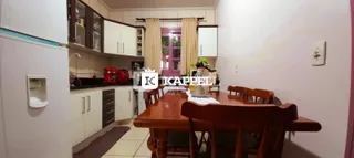 Foto de uma sala de jantar com mesa de madeira e cadeiras.
