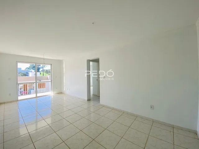 Ambiente interno de uma sala com piso de cerâmica e porta de vidro.
