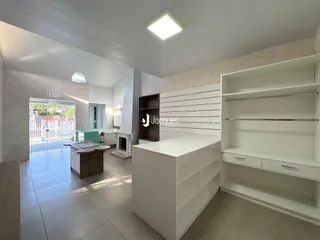 Ambiente interno de uma sala de estar com piso de cerâmica e porta de vidro que dá acesso ao exterior.