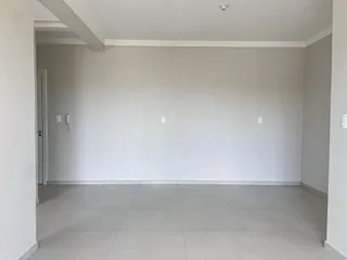 Hall de entrada com paredes brancas e piso de cerâmica.