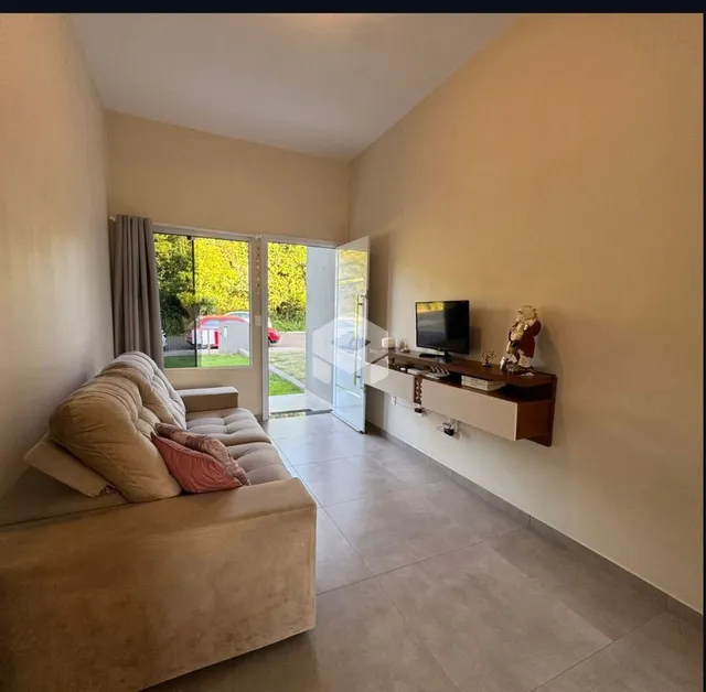 Sala de estar com sofá e porta de vidro iluminada.