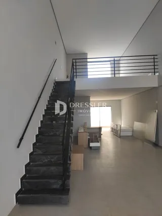 Vista de uma escadaria e área de passagem em um imóvel.