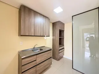Vista da área da cozinha com armários e bancada de granito.