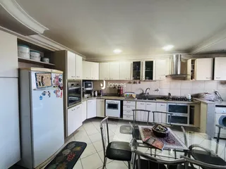 Imagem de uma cozinha com armários brancos e bancada em Lajeado.