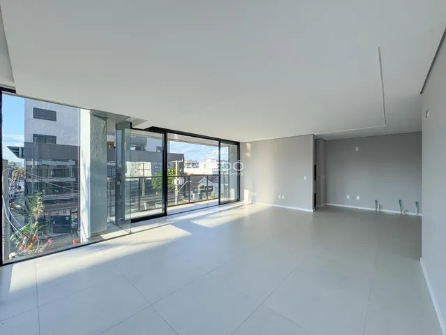 Sala de estar ampla com grandes portas de vidro que dão para o exterior.