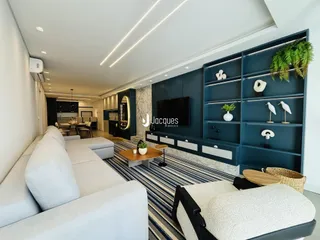 Sala de estar moderna com sofá e estantes em um apartamento.