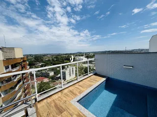 Vista de uma varanda com piscina e paisagem urbana em Lajeado.