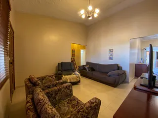 Sala de estar com sofás e piso de madeira em um imóvel em Lajeado.