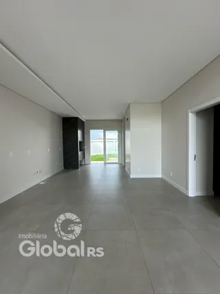 Um corredor amplo com piso cinza e paredes brancas.