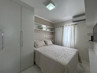 Quarto com cama e armários brancos em um imóvel no Brasil.