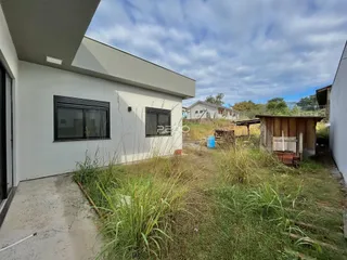 Vista da fachada de uma residência em Lajeado, Brasil, com jardim com vegetação alta.