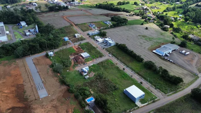 Vista aérea de um terreno rural com áreas abertas e estruturas dispersas.