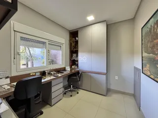 Ambiente de escritório com janela e armários em um imóvel no Brasil.