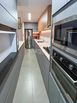 Vista interna de uma cozinha moderna com armários e eletrodomésticos em Lajeado.