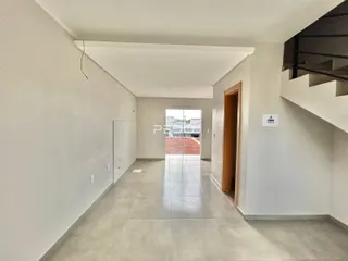 Corredor interno de uma residência com paredes brancas e piso de cerâmica.