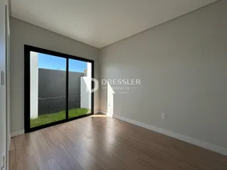 Sala de estar com piso de madeira e porta de vidro voltada para o exterior.