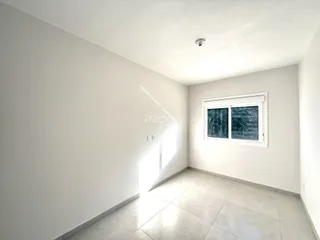 Interior de um ambiente com paredes brancas e piso de cerâmica claro.