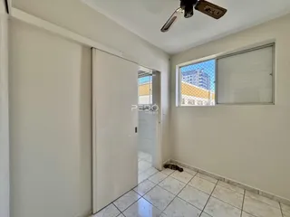 Hall de entrada com paredes brancas e piso de cerâmica.