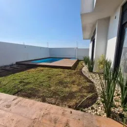 Foto externa mostrando uma piscina e um gramado em uma propriedade.