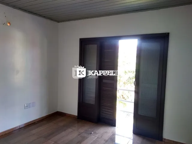 Ambiente interno com piso de madeira e porta de vidro que dá acesso ao exterior.