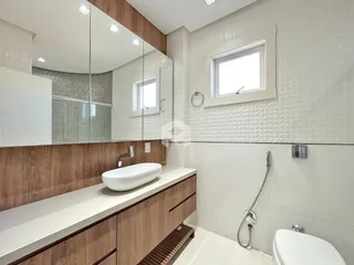 Banheiro com bancada de madeira e revestimento cerâmico