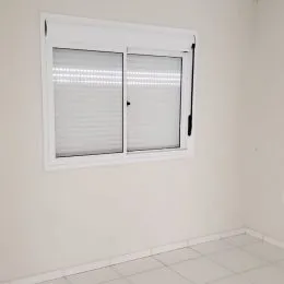 Janela branca com persianas horizontais na parede.