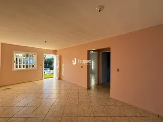 Uma sala com piso de cerâmica clara e uma porta de entrada para outro ambiente.