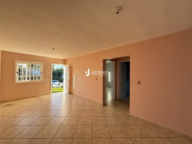 Uma sala com piso de cerâmica clara e uma porta de entrada para outro ambiente.