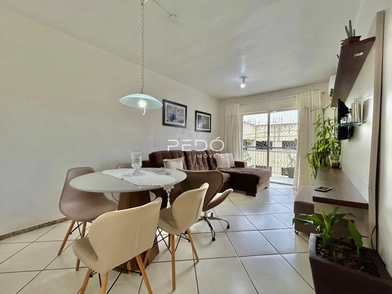 Sala de estar com sofá e mesa de jantar em um apartamento no Brasil.