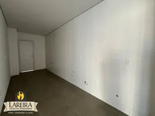 Vista interna de um ambiente com paredes brancas e piso de cerâmica.
