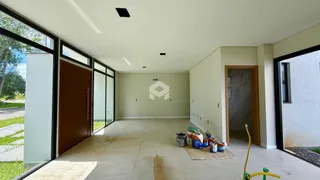Sala ampla com piso de concreto e grandes janelas de vidro.