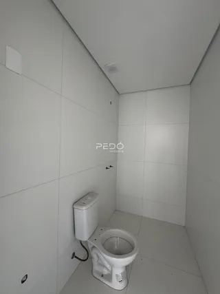 Banheiro com revestimento cerâmico nas paredes e piso claro.