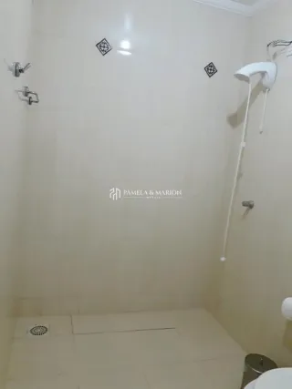 Foto de um banheiro interno com paredes claras e um chuveiro instalado.