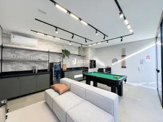 Sala de estar moderna com mesa de bilhar e cozinha integrada.