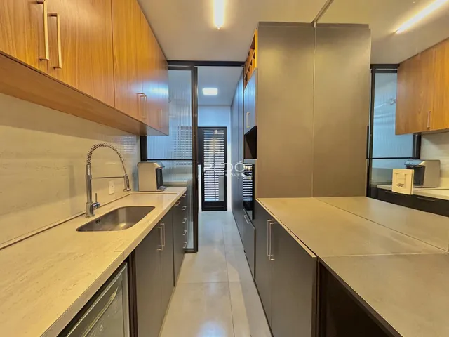 Cozinha moderna com armários de madeira e bancadas claras.