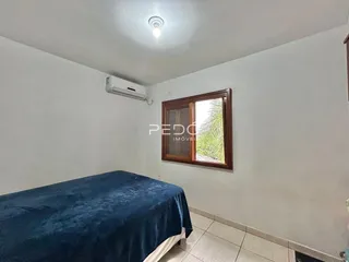 Quarto com cama e janela em ambiente claro.
