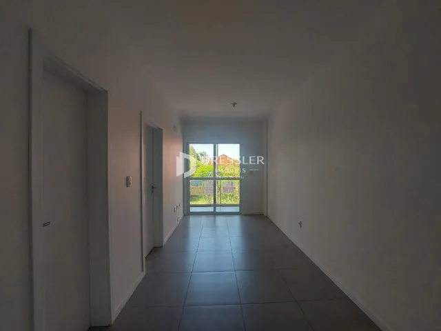 Corredor interno de uma residência com piso de cerâmica.
