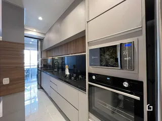 Vista da cozinha moderna com armários e eletrodomésticos em Lajeado.