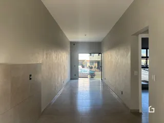 Corredor interno de uma residência com piso de cerâmica.