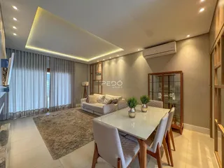 Sala de estar e jantar moderna com piso claro e decoração contemporânea.