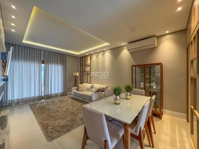Sala de estar e jantar moderna com piso claro e decoração contemporânea.