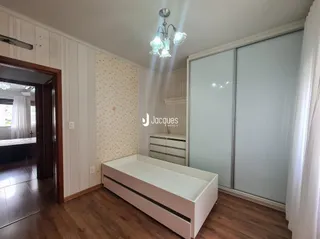 Ambiente interno de uma sala com piso de madeira e divisórias brancas.