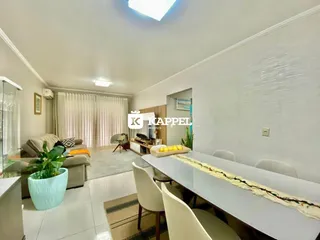 Sala de estar com sofá e mesa de jantar em um apartamento.